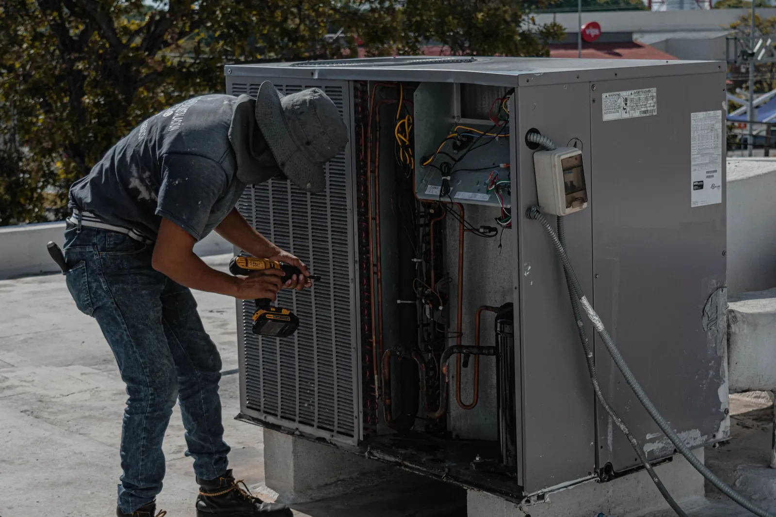 Technician servicing a rooftop condensing unit
