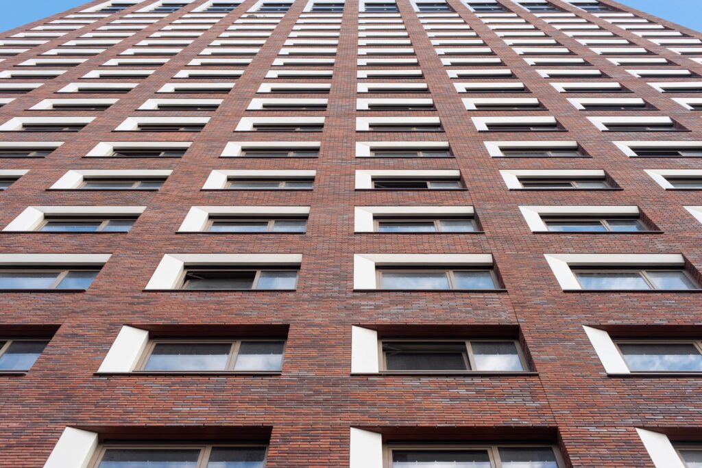 Tall brick building facade with rows of windows