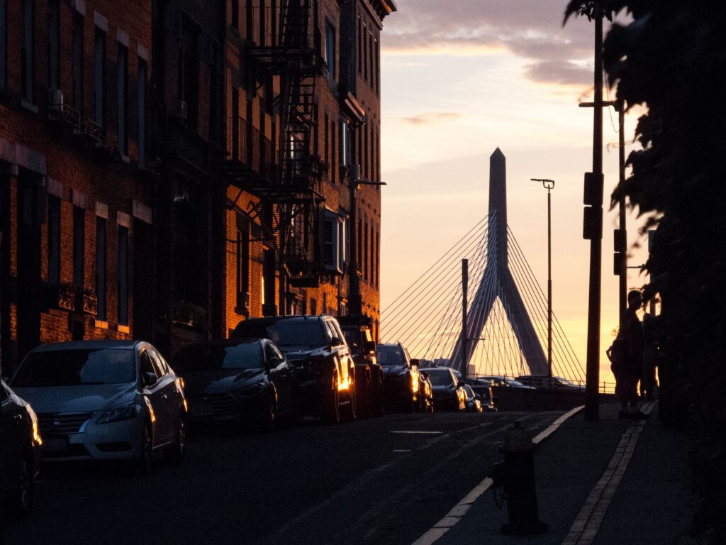 Boston street at sunset with the Zakim Bridge in the distance