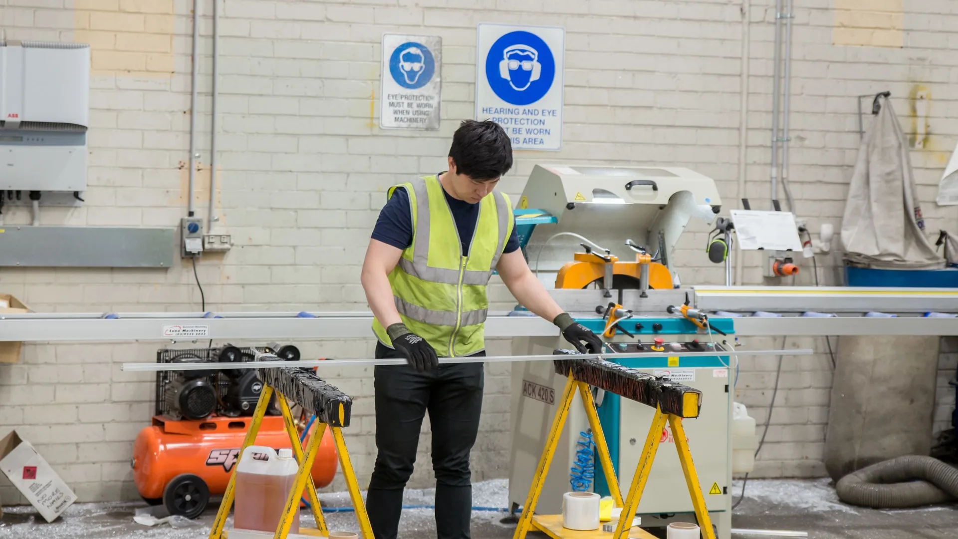 Technician in safety vest working in a mechanical shop